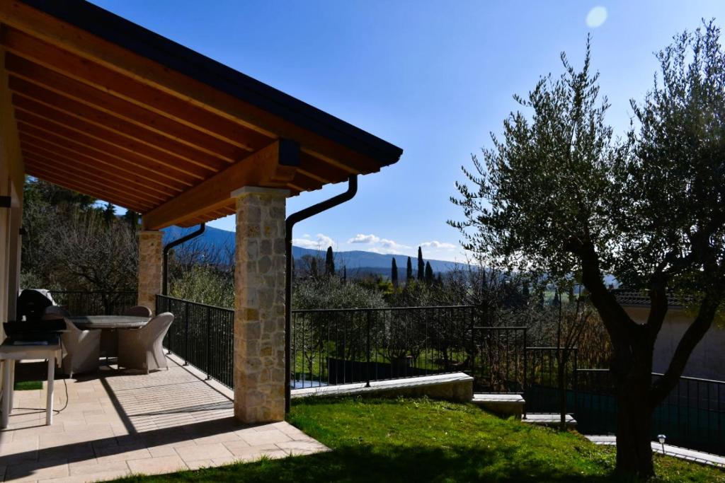 a patio with a roof with a table and chairs at Villetta Giare in Posina