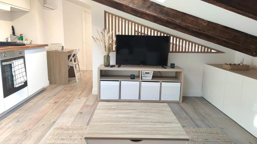 un salon avec une télévision à écran plat sur une armoire dans l'établissement Gubernatis centre ville, à Nice