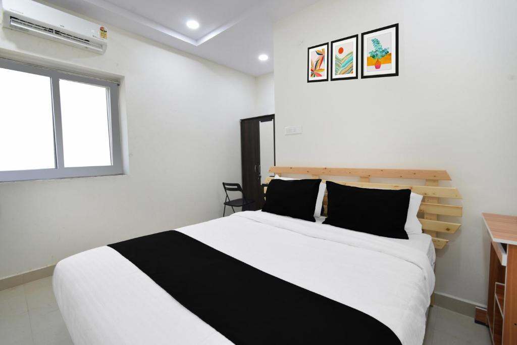 a bedroom with a black and white bed and a window at Super Collection O Adibatla Hyderabad in Ibrāhīmpatan