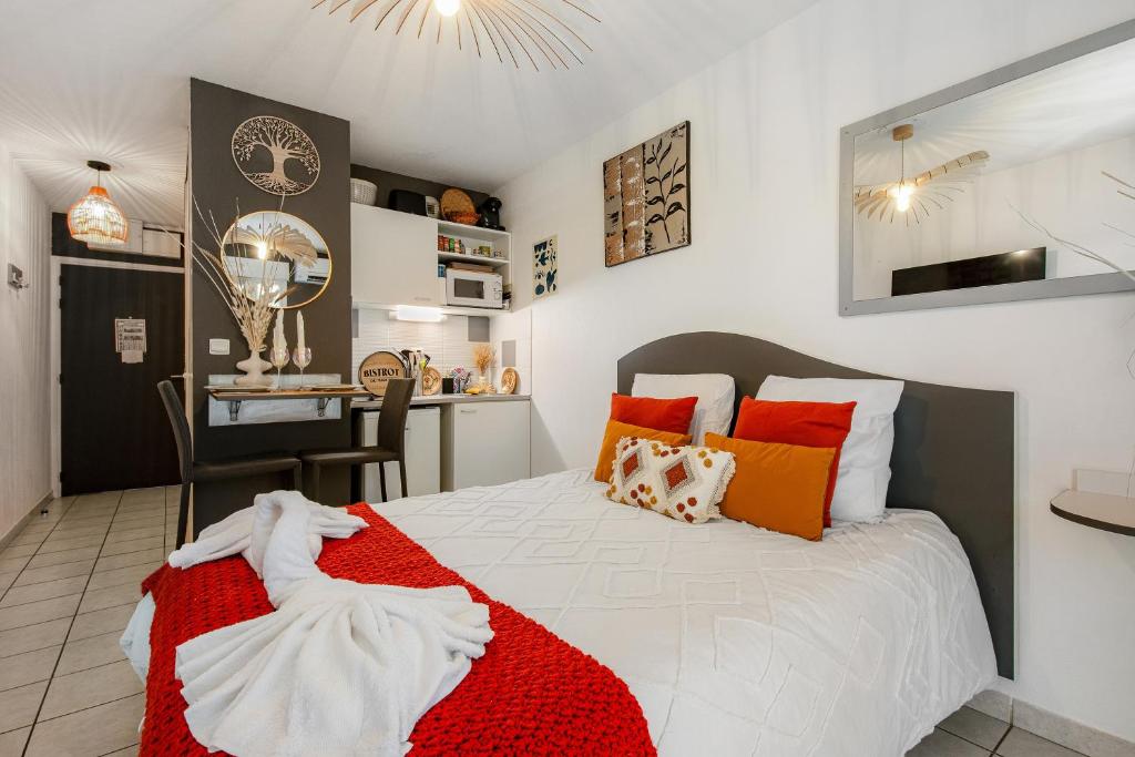 - une chambre dotée d'un lit avec une couverture rouge et blanche dans l'établissement Le Flamboyant du Fonserane - Climatisé, à Béziers