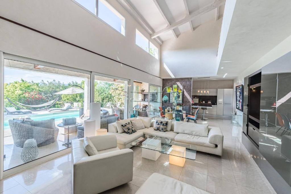 un salon avec des meubles blancs et une grande fenêtre dans l'établissement Diane By Terrys Homes, à Cannes