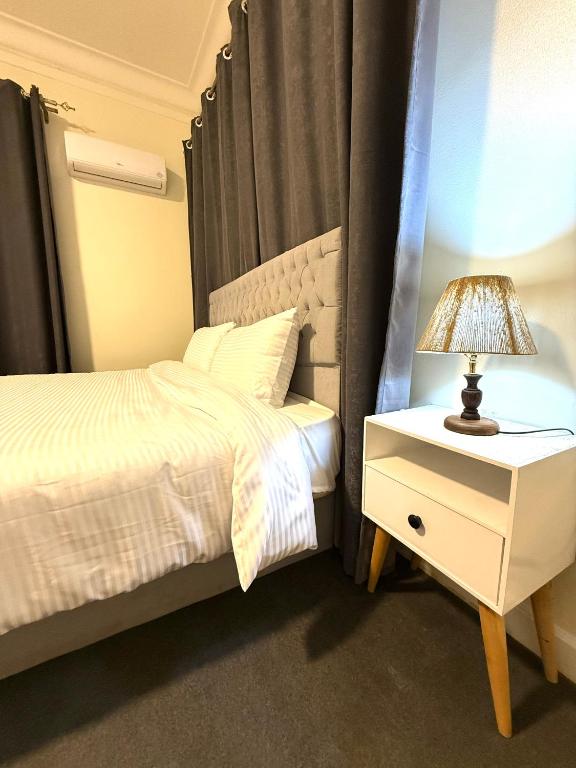 a bedroom with a bed and a lamp on a night stand at غرفة أنيقة في قلب القاهرة in Cairo