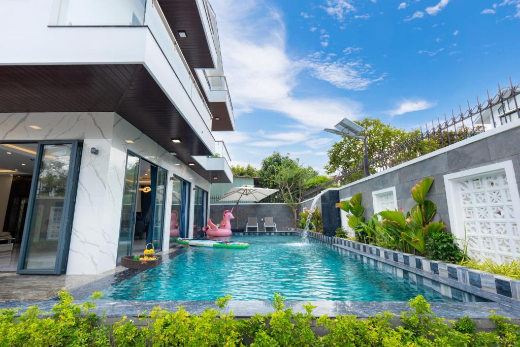 a swimming pool outside of a building with a resort at Villa B2-34 Long Cung - 8 phòng ngủ - 100m tới biển in Vung Tau