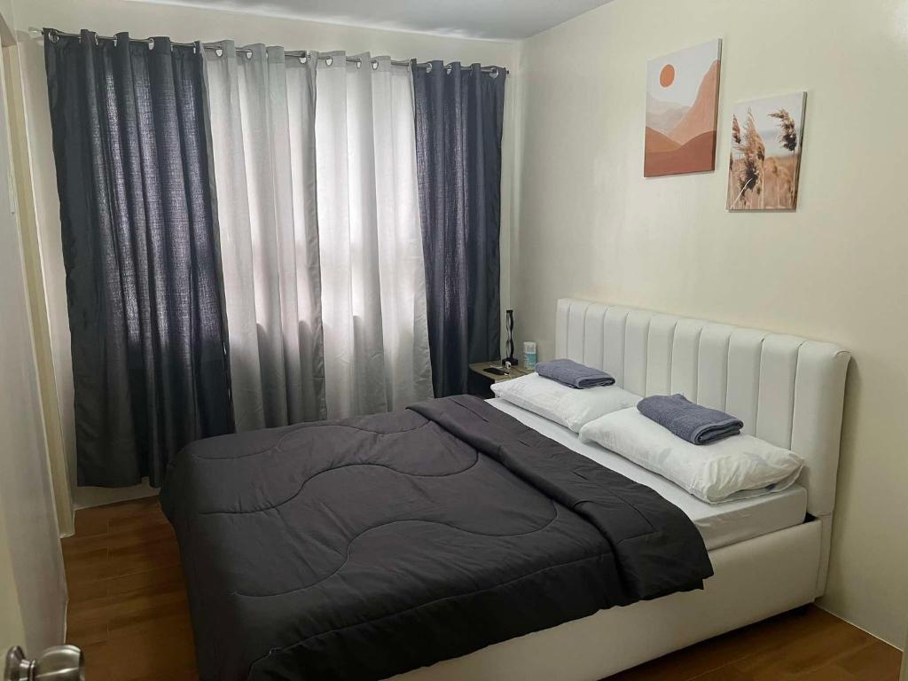 ダバオシティにあるVin's Cloud9 Queen Bed Netflix SMX-Davao Airport-Samal Ferryの窓のある大きなベッドのある寝室