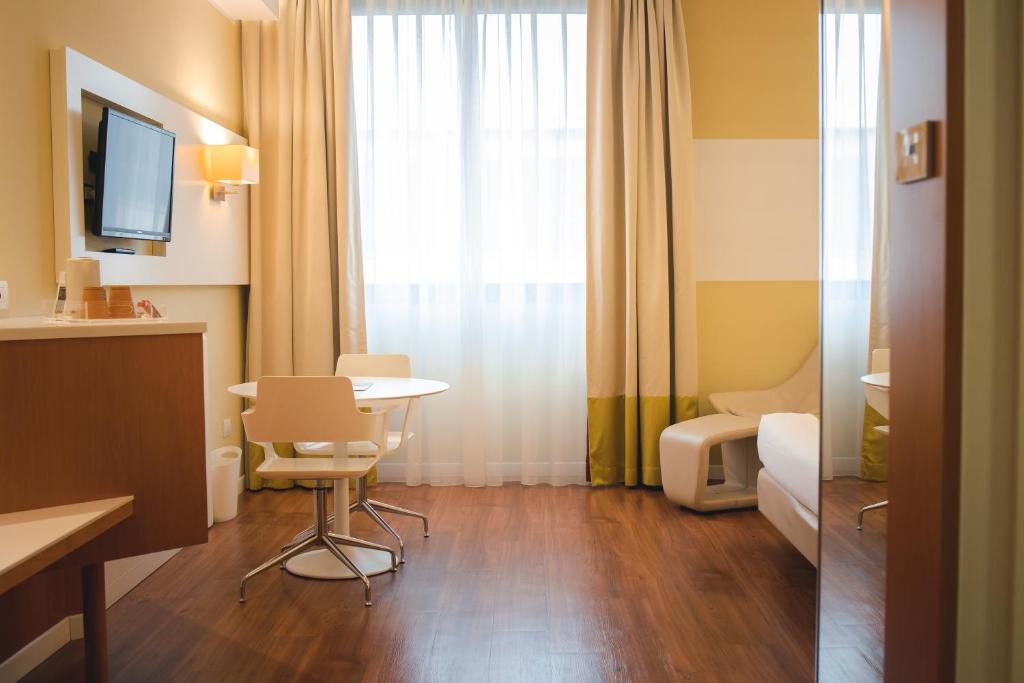 pokój hotelowy ze stołem i oknem w obiekcie Best Western Mirage Hotel Fiera w mieście Paderno Dugnano
