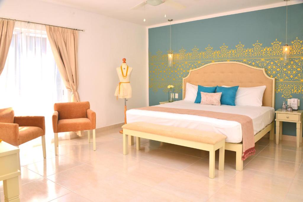 1 dormitorio con 1 cama con pared azul y amarilla en Unic Design Hotel - 5th Avenue, en Playa del Carmen