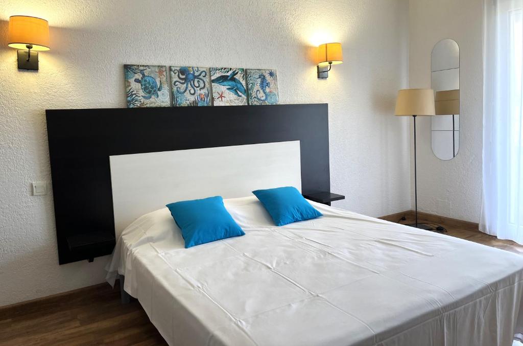 een slaapkamer met een groot bed met 2 blauwe kussens bij SAINT FLORENT - Studio 3 pers balcon vue mer FLO127 in Saint-Florent