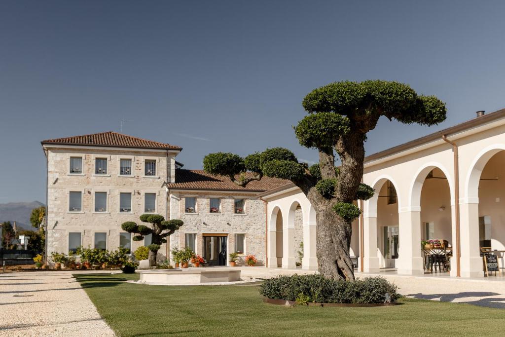 a large building with a tree in front of it at Casa de Eli - Tenuta Torre Zecchei Wine Experience in Valdobbiadene