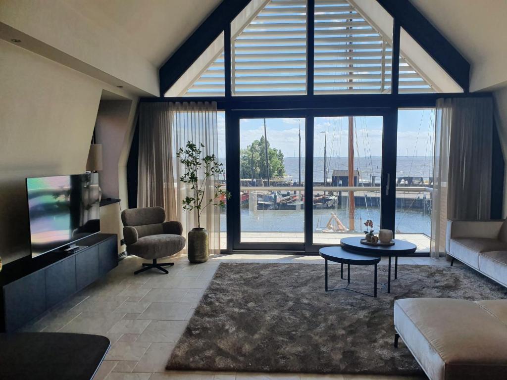 een woonkamer met een groot raam met uitzicht bij Vakantiehuis Botterhaven Urk in Urk