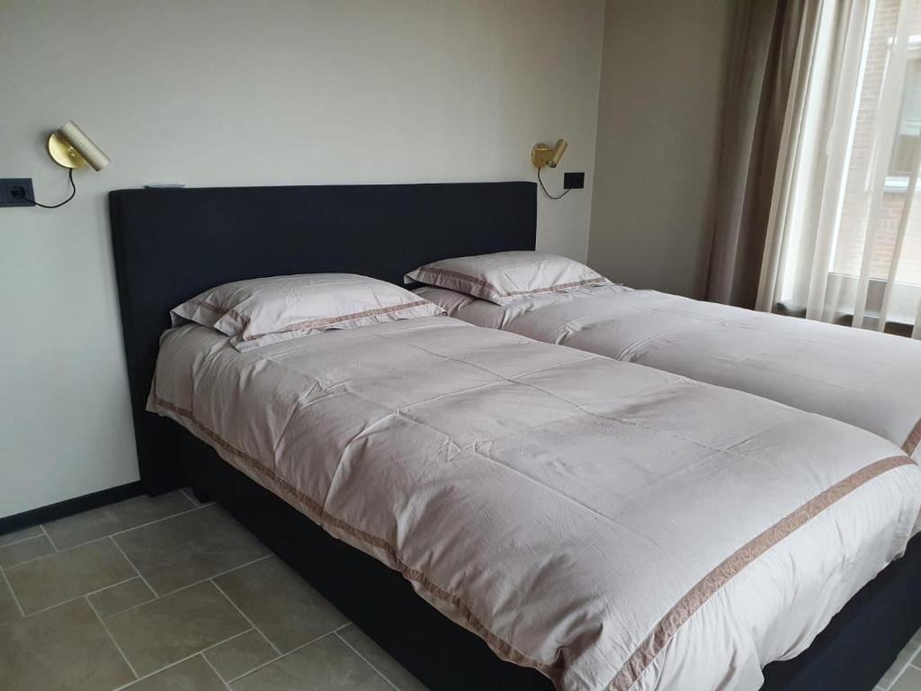 twee bedden naast elkaar in een slaapkamer bij Vakantiehuis Botterhaven Urk in Urk
