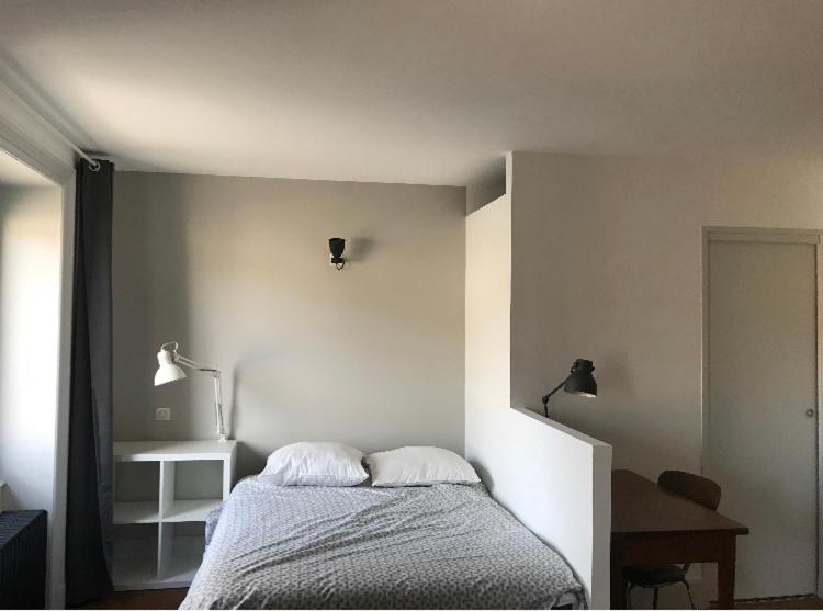 ein Schlafzimmer mit einem Bett mit zwei Kissen darauf in der Unterkunft Chambres indépendantes Centre Ville Yssingeaux in Yssingeaux