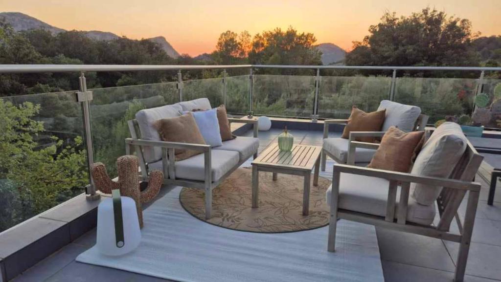 a patio with couches and a table on a balcony at Villa Lucitello by Monarca, refuge Familial 5 personnes à 10 minutes de Saint Florent in Barbaggio