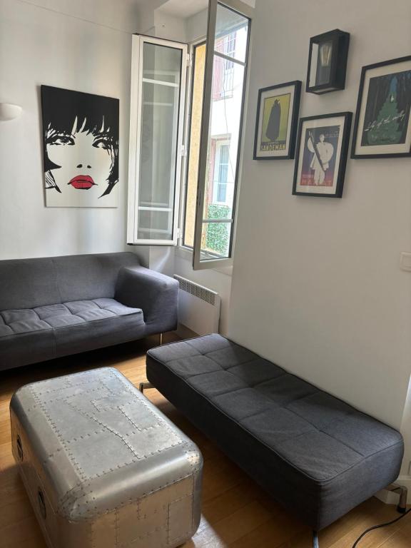 - un salon avec un canapé et un pouf dans l'établissement 2 bedroom funky apartment in the heart of the old town of Antibes, à Antibes