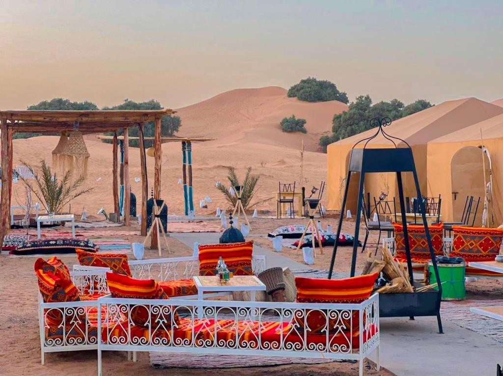 un grupo de sillas y mesas en el desierto en Tenere desert luxury camp, en Merzouga