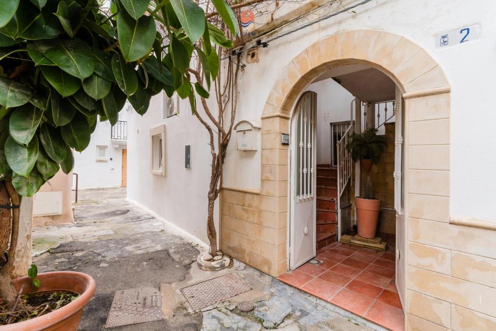 an entrance to a building with a tree in a courtyard at Dimora Cantalupi by Vivimy in Gallipoli