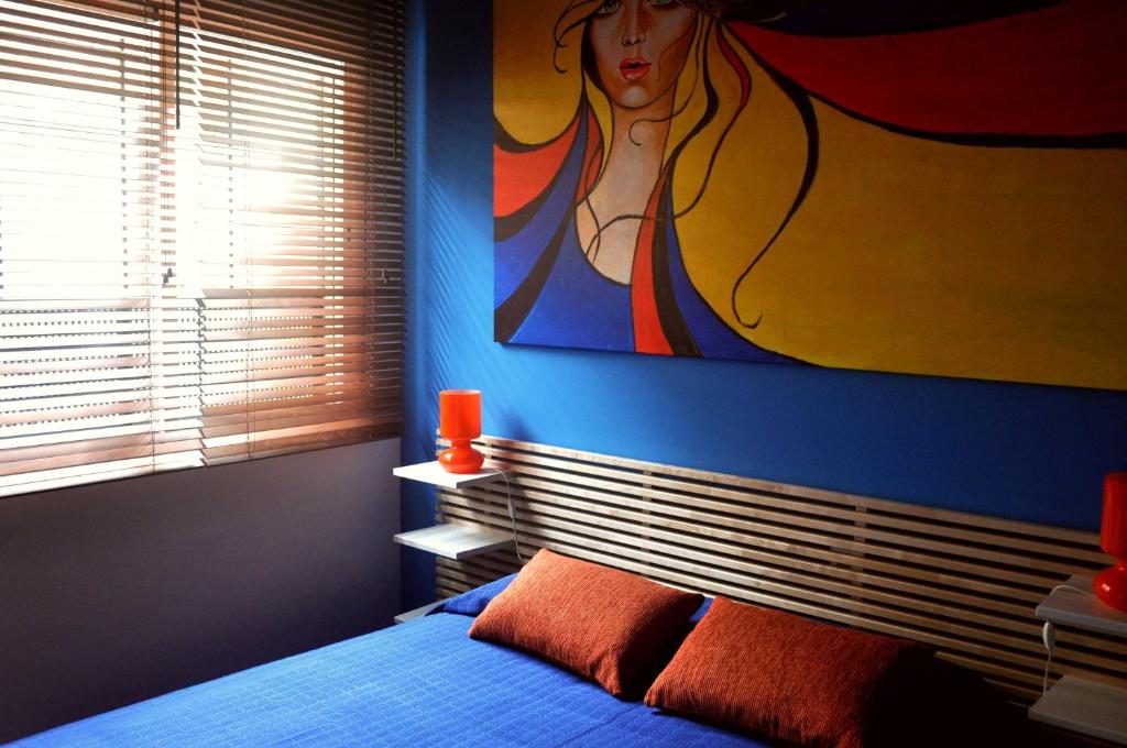 a bedroom with a painting of a woman on the wall at Sevillarent in Seville