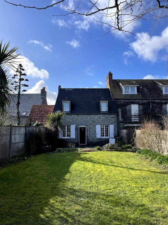 une vieille maison en pierre avec une grande cour dans l'établissement L'Inattendue, à Saint-Vaast-la-Hougue