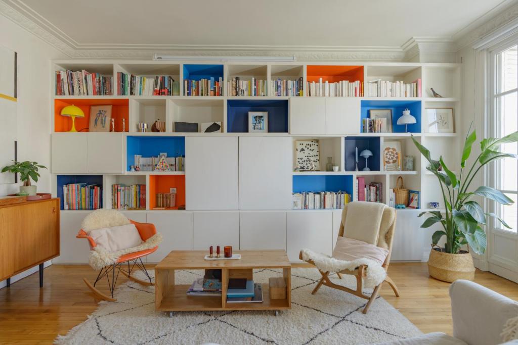 un salon avec des étagères blanches et bleues dans l'établissement Paris Les Amandiers Residence, à Paris