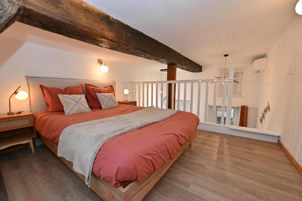 - une chambre avec un grand lit et des draps rouges dans l'établissement Le pastoureau cozy hyper centre, à Sens