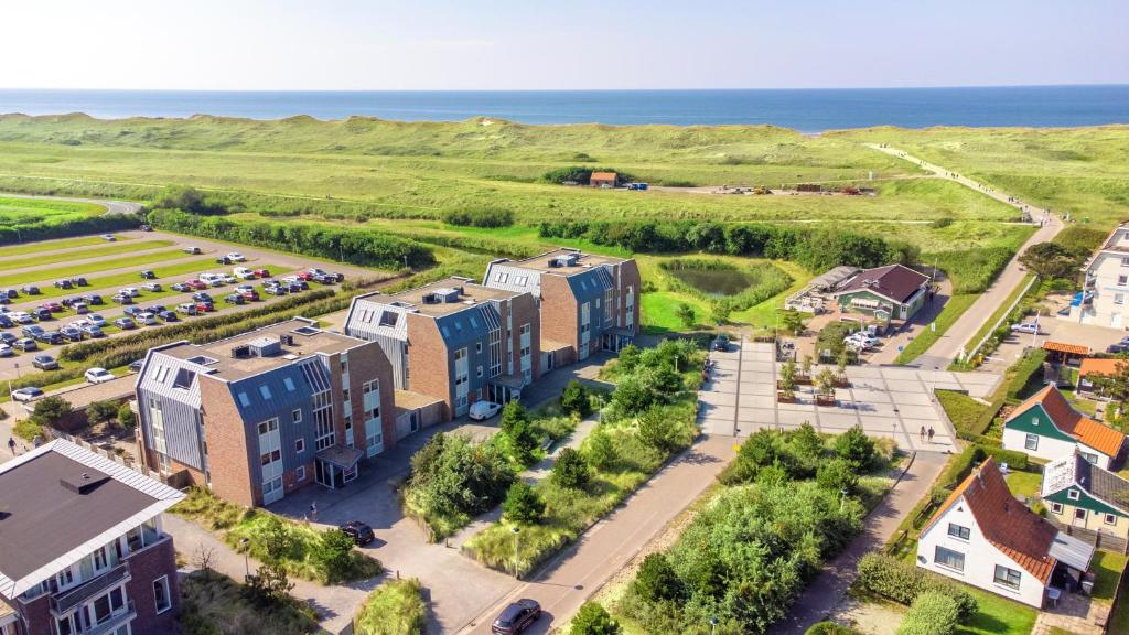 an aerial view of a building with the ocean in the background at Duinerei Groote Keeten in Callantsoog