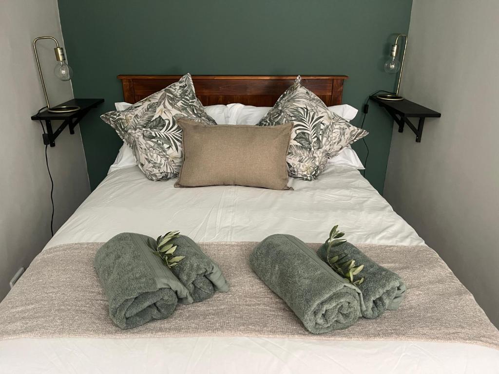 a bed with two pillows and towels on it at Te Môi in Paarl