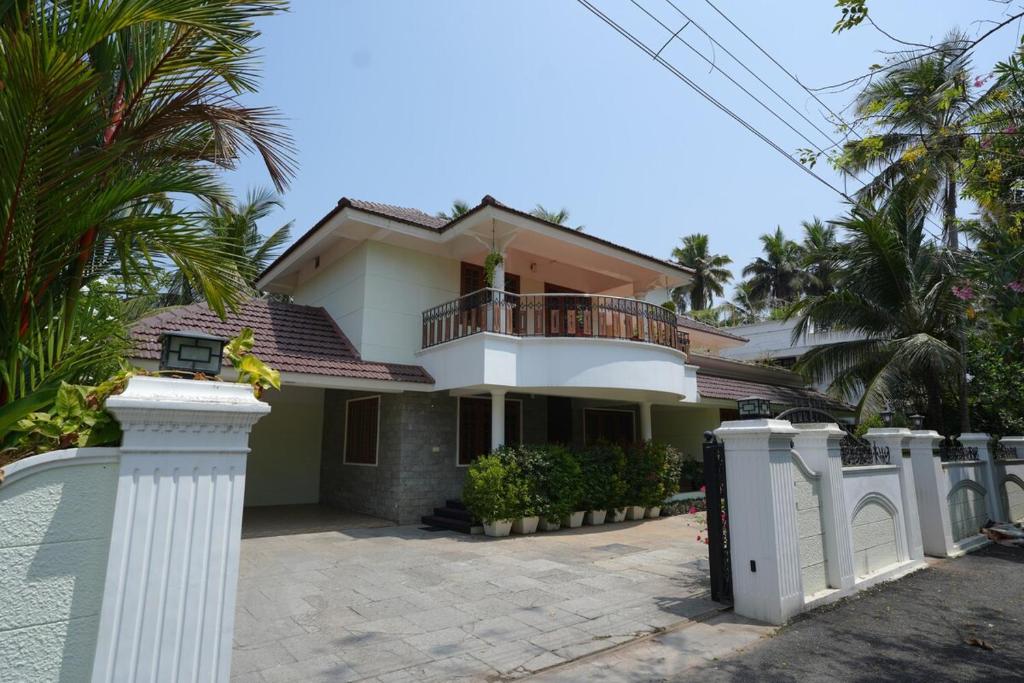 una casa con una valla blanca delante en Pinky's Villa, en Trivandrum