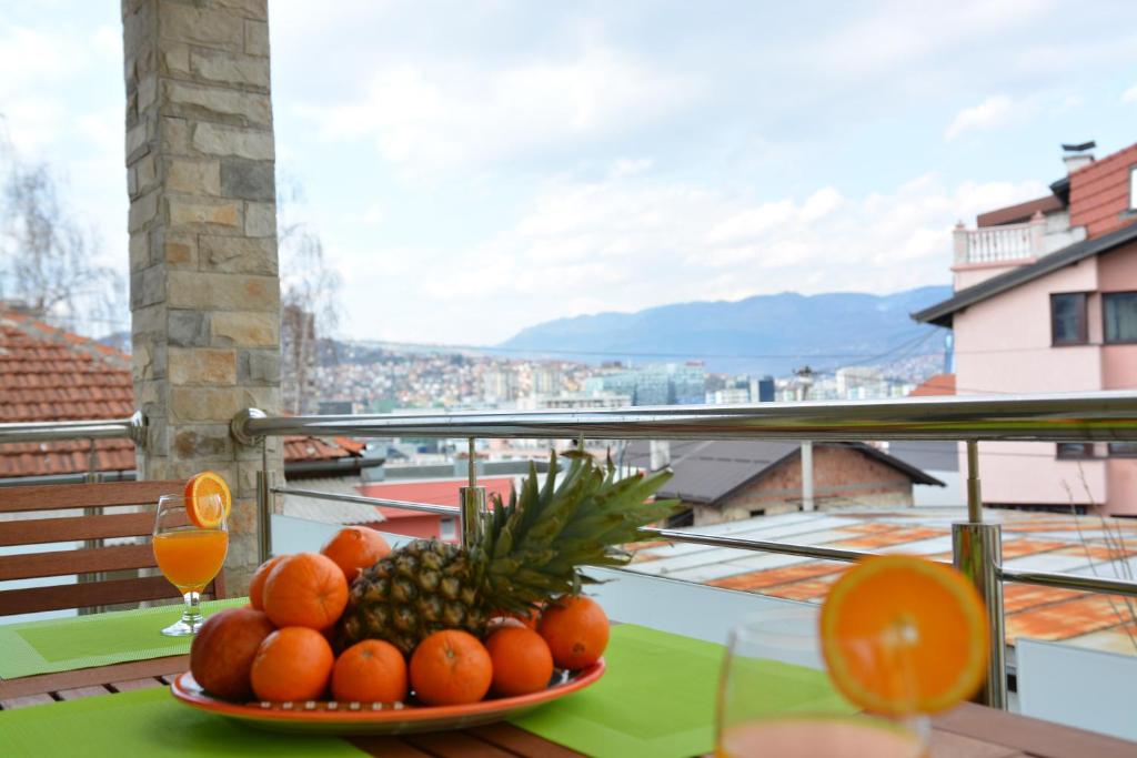 شقة ميريلا في سراييفو: صحن من البرتقال والأناناس على طاولة في الشرفة