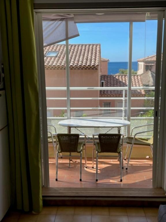 une table et des chaises sur un balcon avec vue sur l'océan dans l'établissement Studio dans le village des pecheurs de Carro, à Martigues
