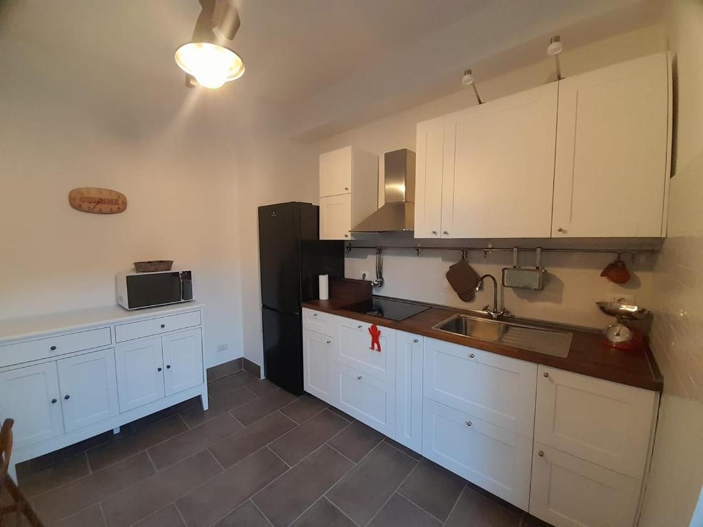 eine Küche mit weißen Schränken und einem schwarzen Kühlschrank in der Unterkunft The Mountain View - Casa a Castello in Castel di Sangro