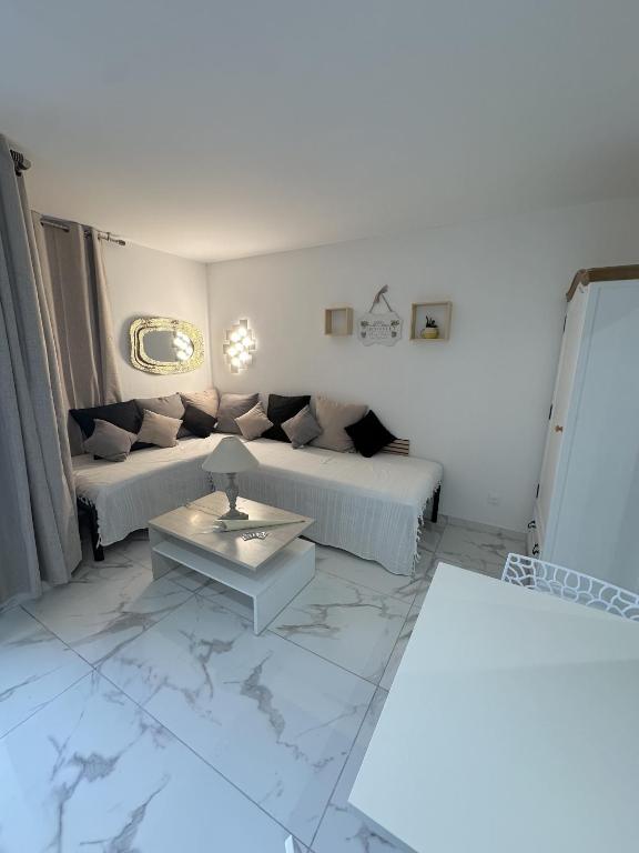 un salon avec deux lits et une table dans l'établissement Résidence Graziella Studio 107, à Juan-les-Pins