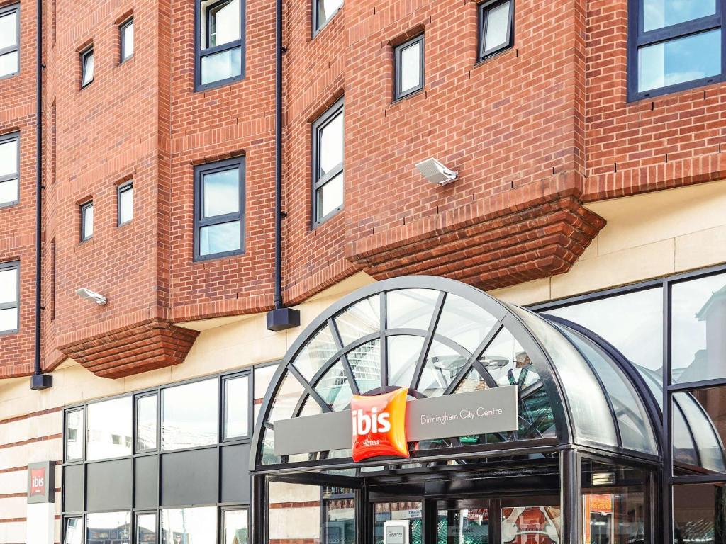 a big sign in front of a brick building at ibis Birmingham Centre New Street Station Hotel in Birmingham