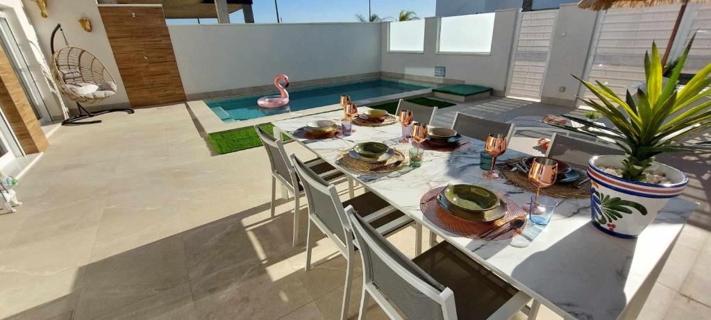a table with a plate of food and a potted plant at Casa LaryLen - with private pool and big solarium close to the beach and childfriendly! in Santiago de la Ribera