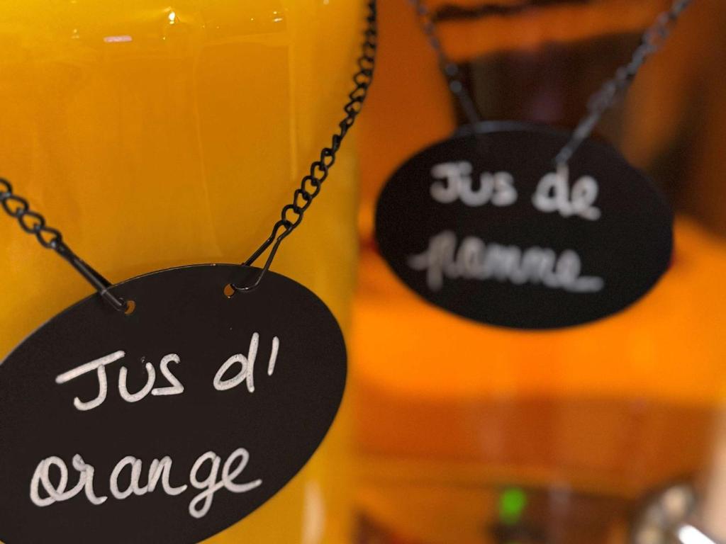 two black signs on a chain next to a drink at Hotel Ibis Budget Cosne Sur Loire in Cosne-Cours-sur-Loire