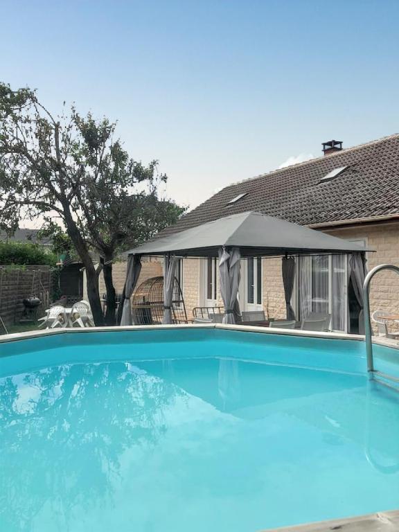 une grande piscine bleue avec une tente dans l'établissement Villa charmante à Saint-Martin-Longueau avec piscine privée, à Saint-Martin-Longueau