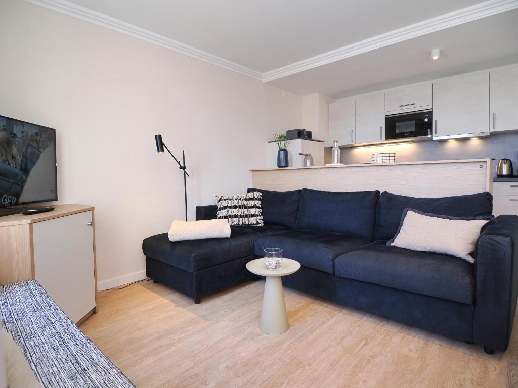 ein Wohnzimmer mit einem blauen Sofa und einem Tisch in der Unterkunft Seehof Seehof 121 in Bansin