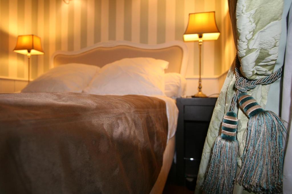 - une chambre avec un lit doté de deux lampes et d'un spectre de lunettes de lit dans l'établissement ParisInteriorsRentals - Beautiful Le Marais NOTRE DAME Appartement, à Paris