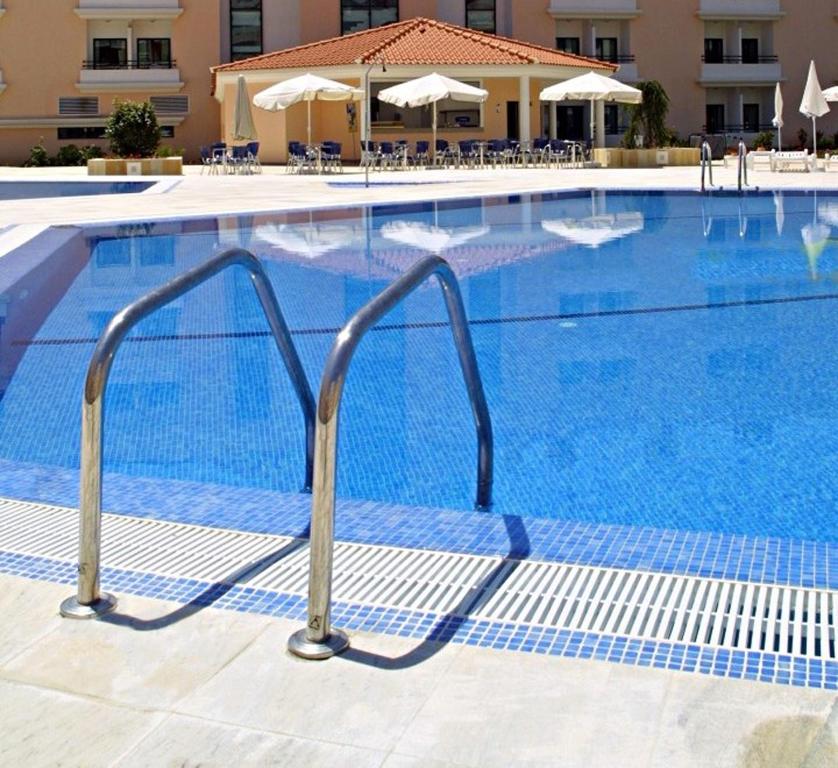a large swimming pool with blue water and a resort at Riviera Hotel in Carcavelos