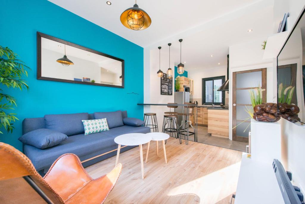 a living room with a blue couch and a table at SV - Au Pied du Vieux Port in Marseille