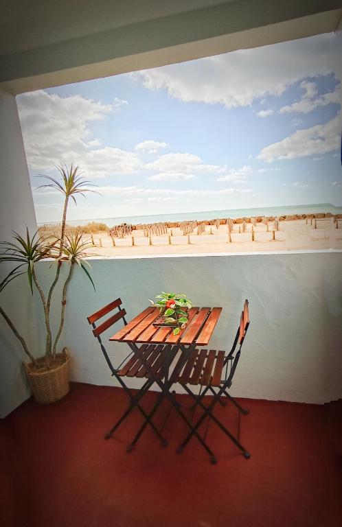 une table et des chaises avec vue sur la plage dans l'établissement Appartement face mer 4 personnes linge de maison et papier toilette non fournis, à Saint-Hilaire-de-Riez