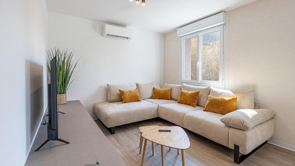 una sala de estar con un sofá y una mesa en Le Dauphiné 6 Allevard, en Allevard