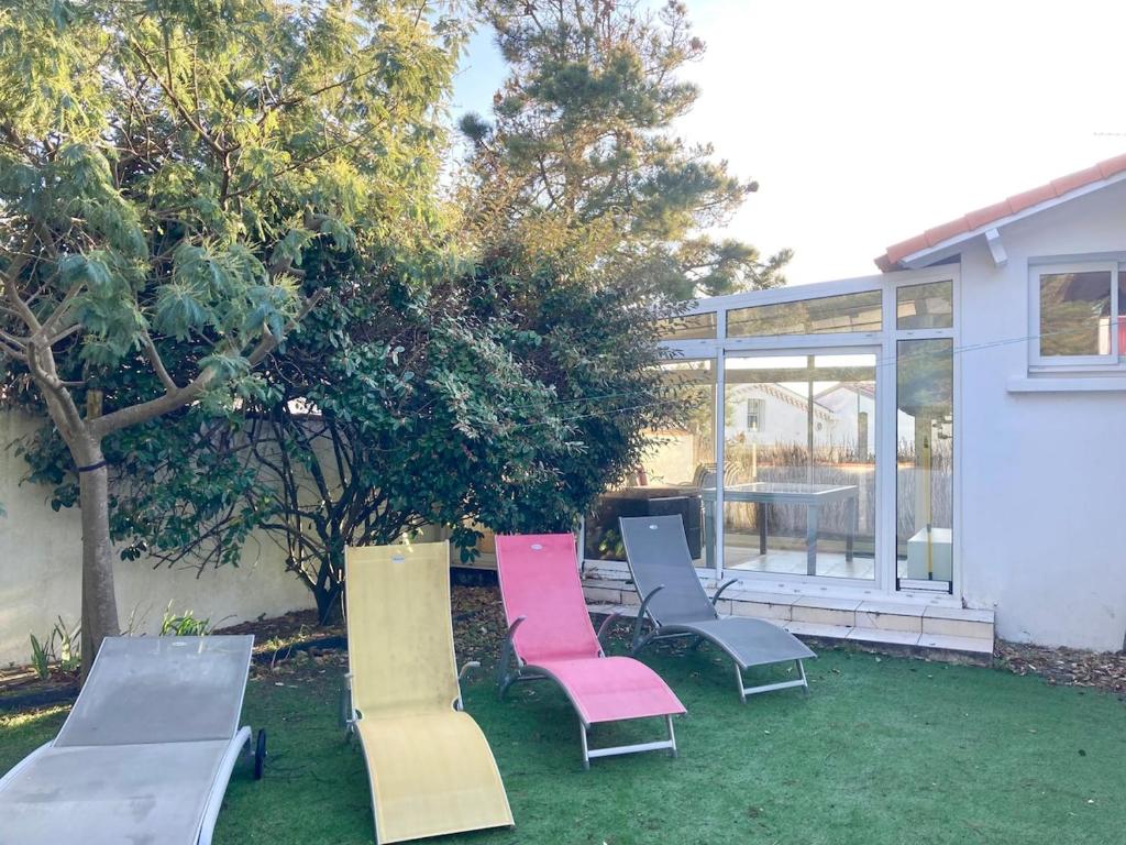 un groupe de chaises et une table dans une cour dans l'établissement Maison paisible à 100m de la Mer, à Bretignolles-sur-Mer