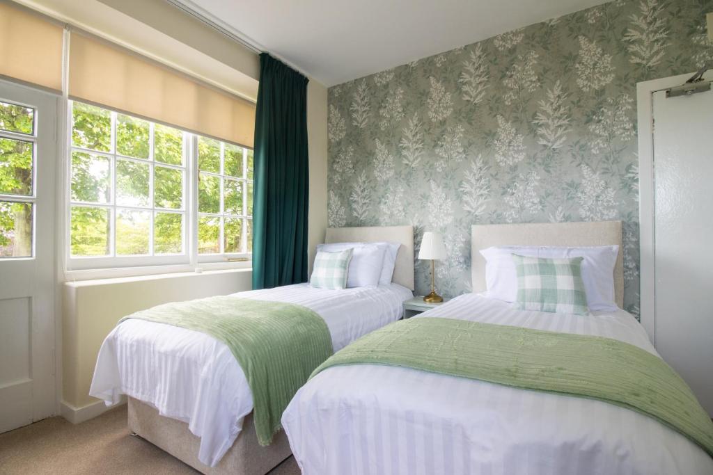 two beds in a bedroom with green and white at Whatton Cottage in Gullane