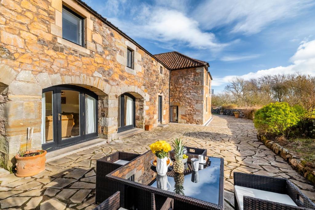 an external view of a stone house with a table and chairs at Moonzie Mill House in Balmullo