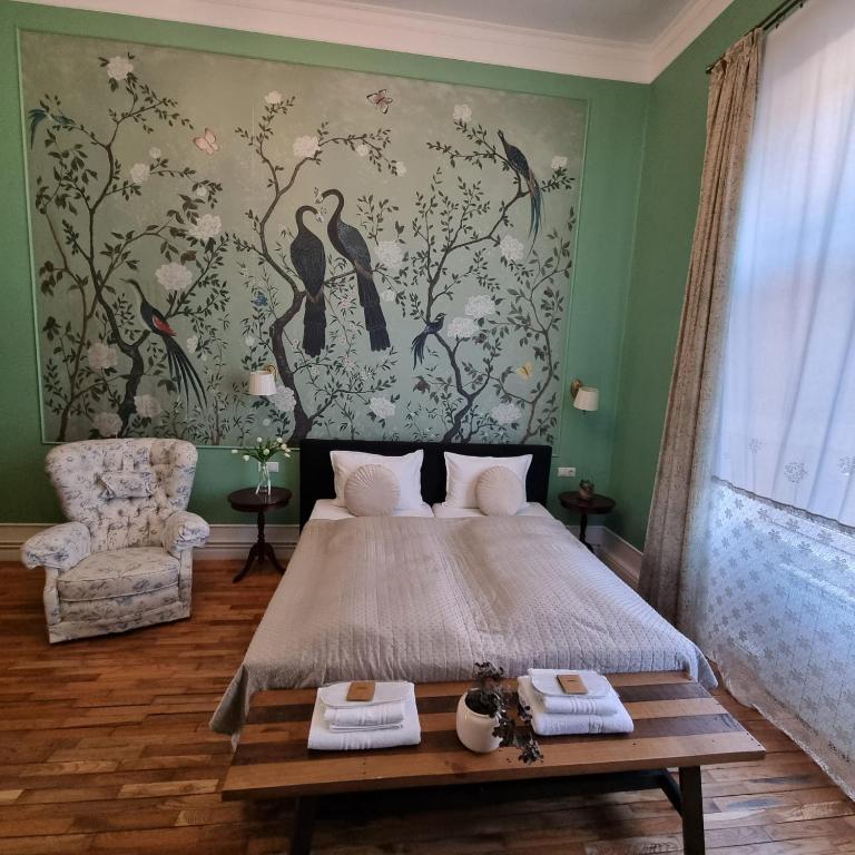 a bedroom with a large bed and a painting of birds at Victoria Apartment 1901-Apartament ultracentral Oradea ,lângă Piața Unirii in Oradea