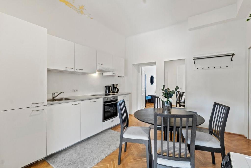 a kitchen and dining room with a table and chairs at Fast Wifi I 4 min to U3 Zipperer Straße in Vienna