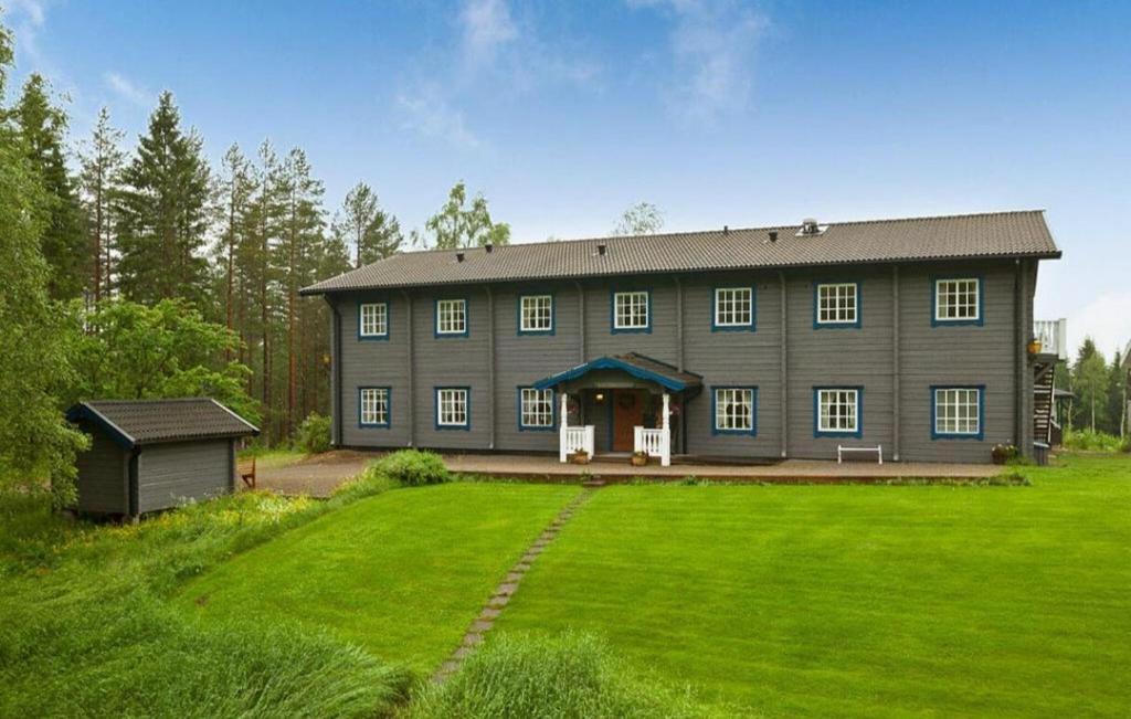 una gran casa gris con un gran patio de césped en 11 Bedroom Gorgeous Home In Torsby, en Torsby