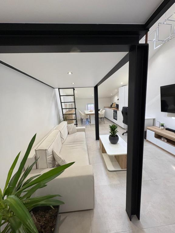 un salon avec un canapé blanc et une télévision dans l'établissement Le Baptiste, à Cannes