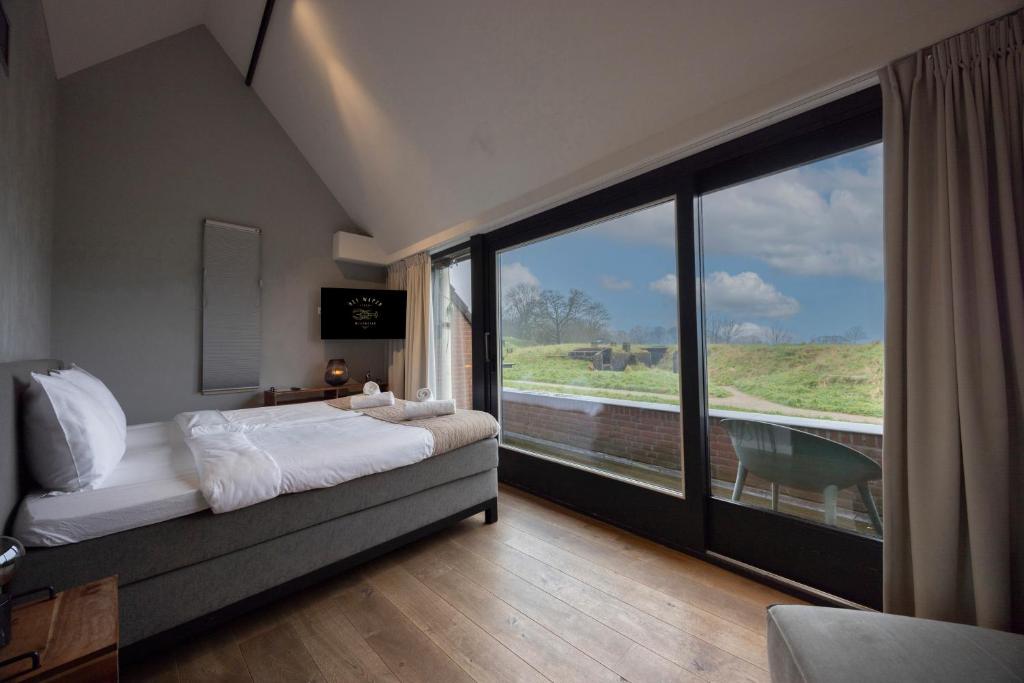 een slaapkamer met een bed en een groot raam bij "Het Wapen Van Willemstad" in Willemstad