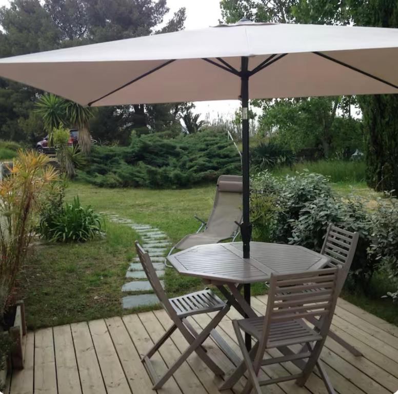 une table et deux chaises sous un parasol dans l'établissement Studio entre mer et montagne, à Taglio-Isolaccio