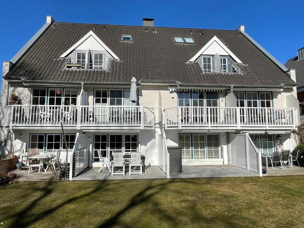 a large white house with a deck and patio at Ferienhaus Sonnenblick in Timmendorfer Strand